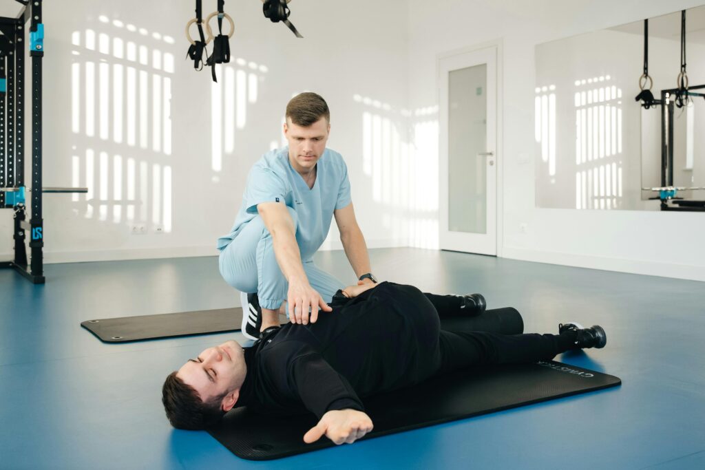 A physiotherapist assisting a patient with stretching exercises indoors.