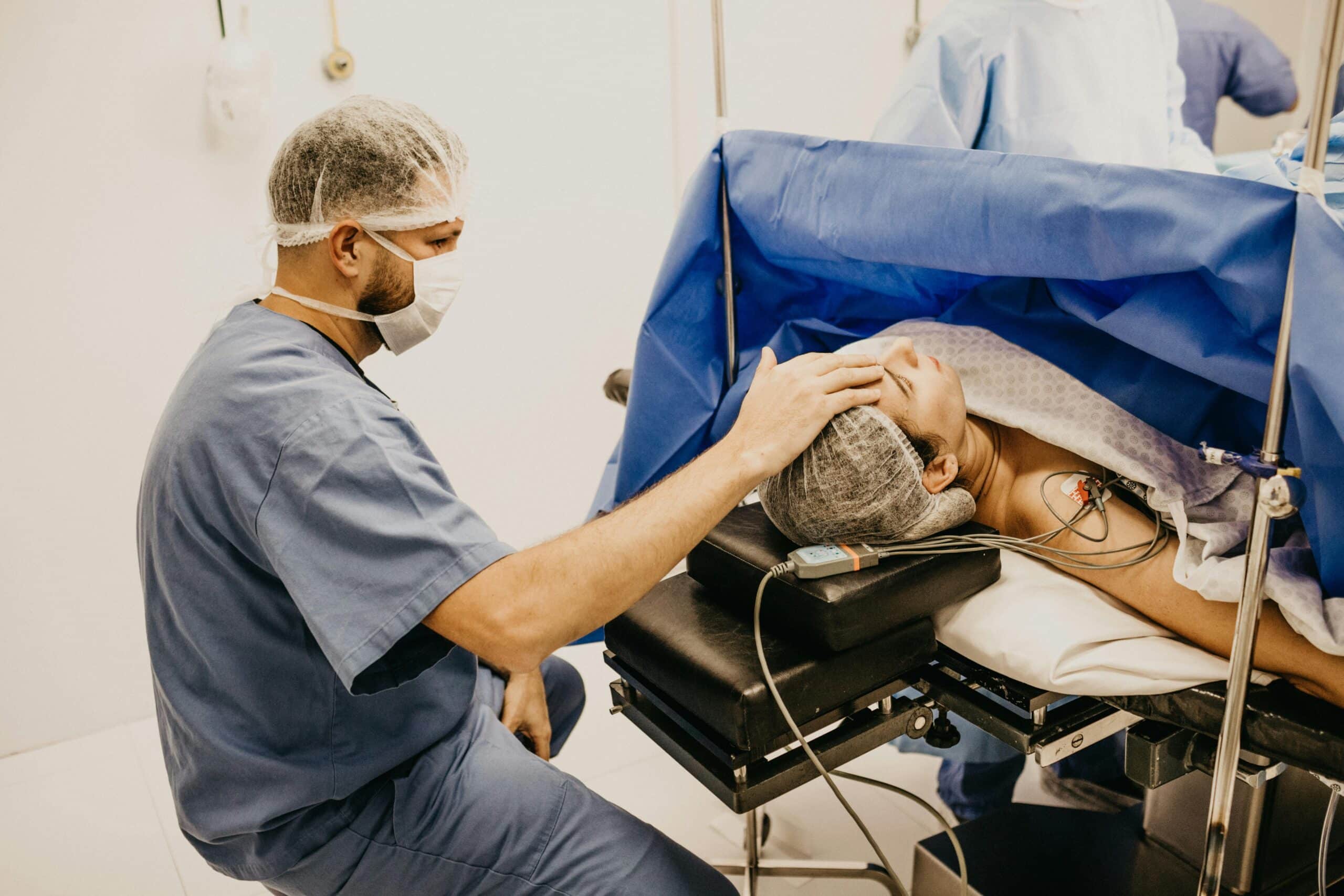 Surgeon offering comfort to a patient about to undergo surgery in a hospital operating room.